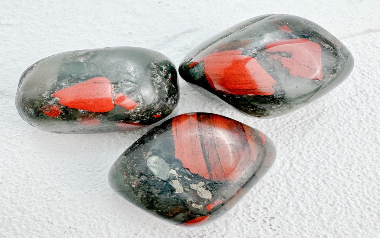 A dark green Bloodstone gemstone with red specks, showcasing its unique and striking appearance