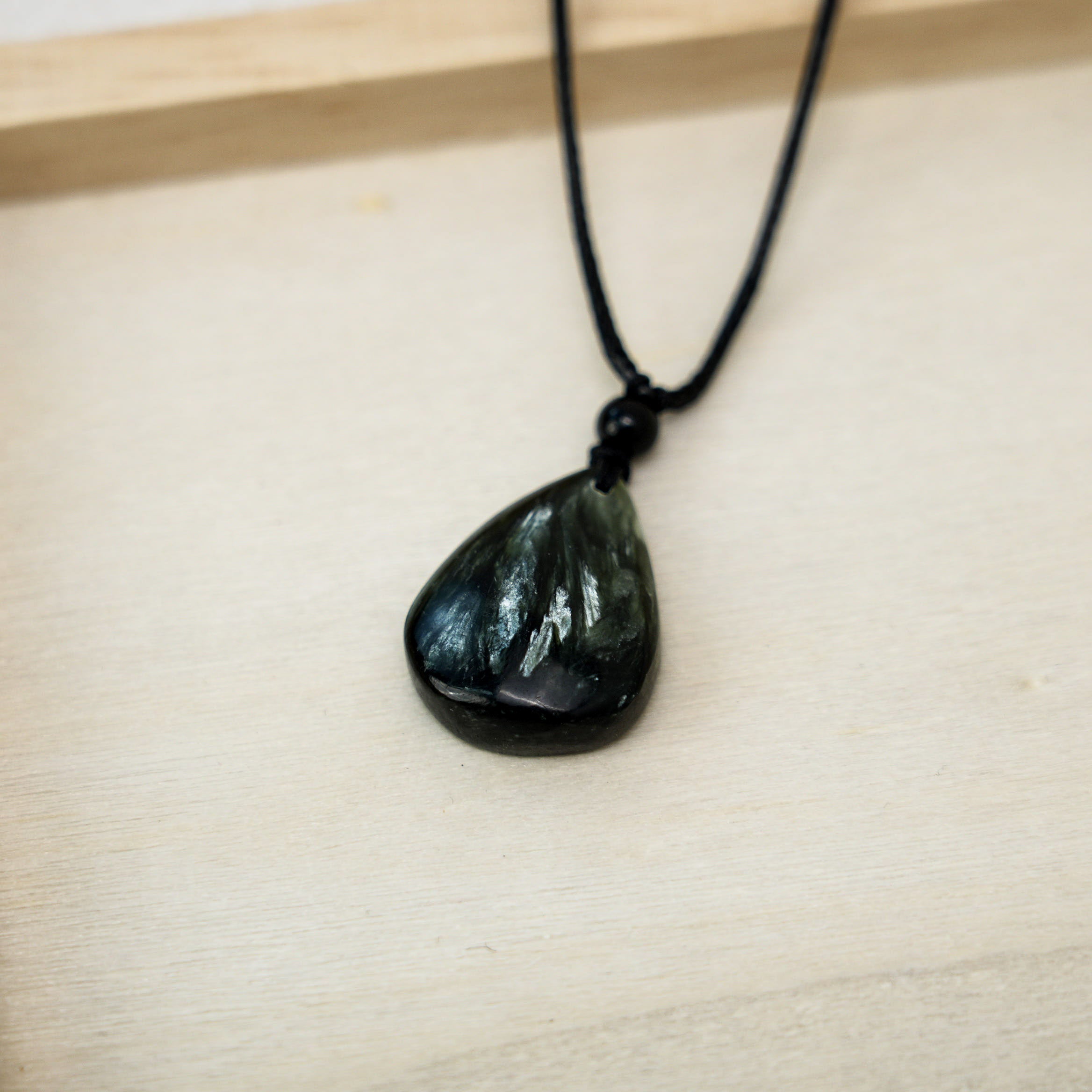 A stunning seraphinite pendant set in sterling silver, perfect for adding a touch of natural elegance to any outfit.