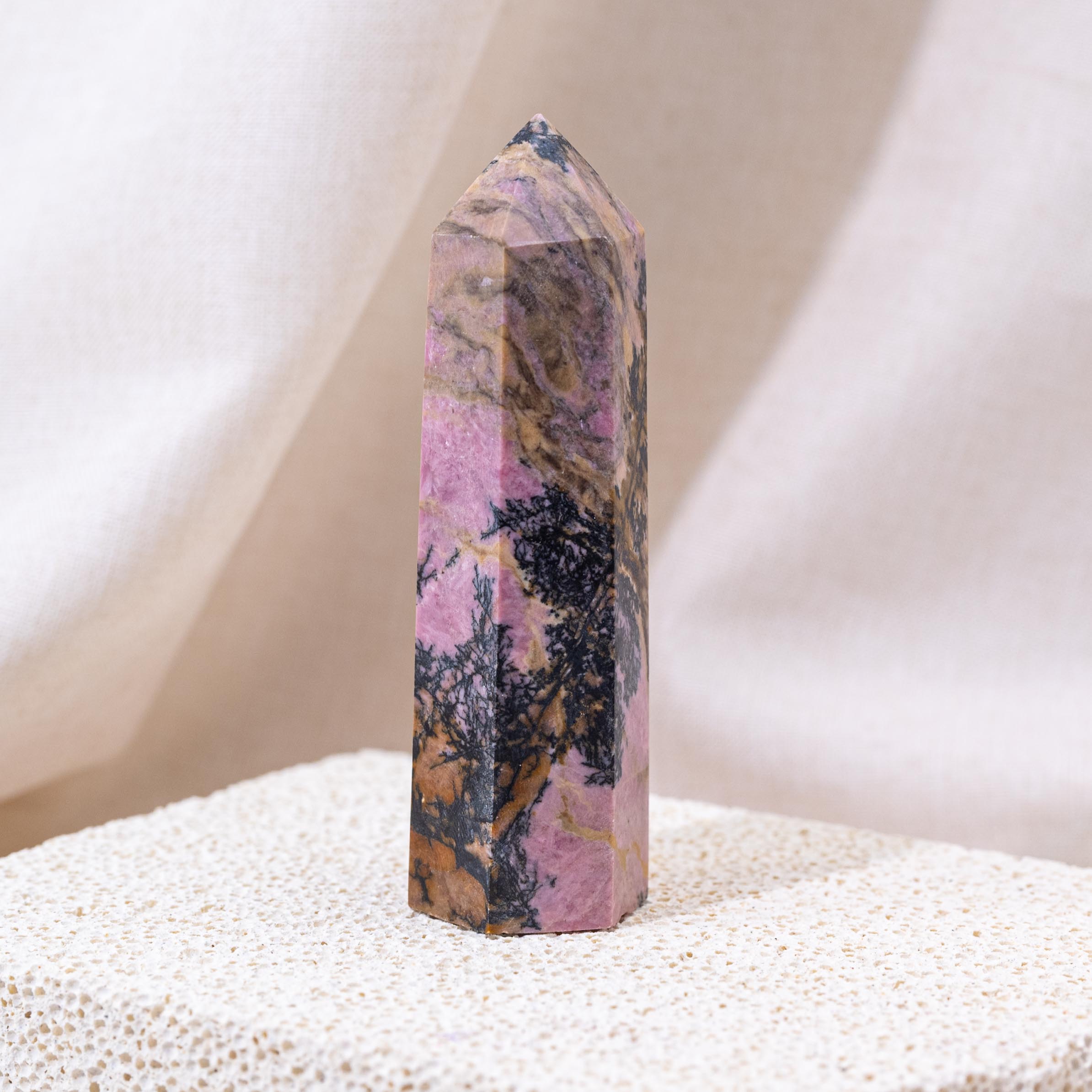 Pink Rhodonite Point with vibrant pink hues.