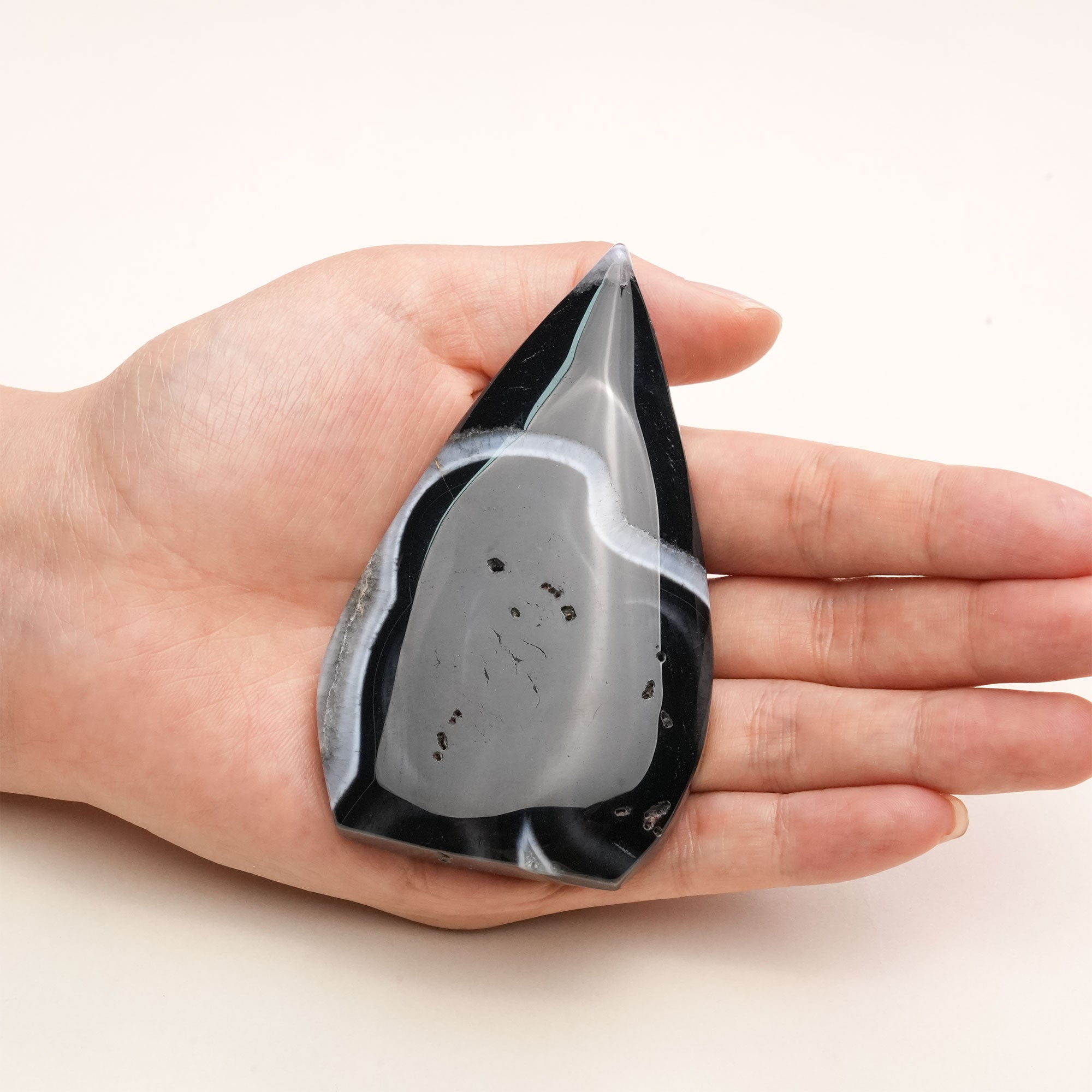 Handheld Black Sardonyx Freeform Crystal emitting protective energy