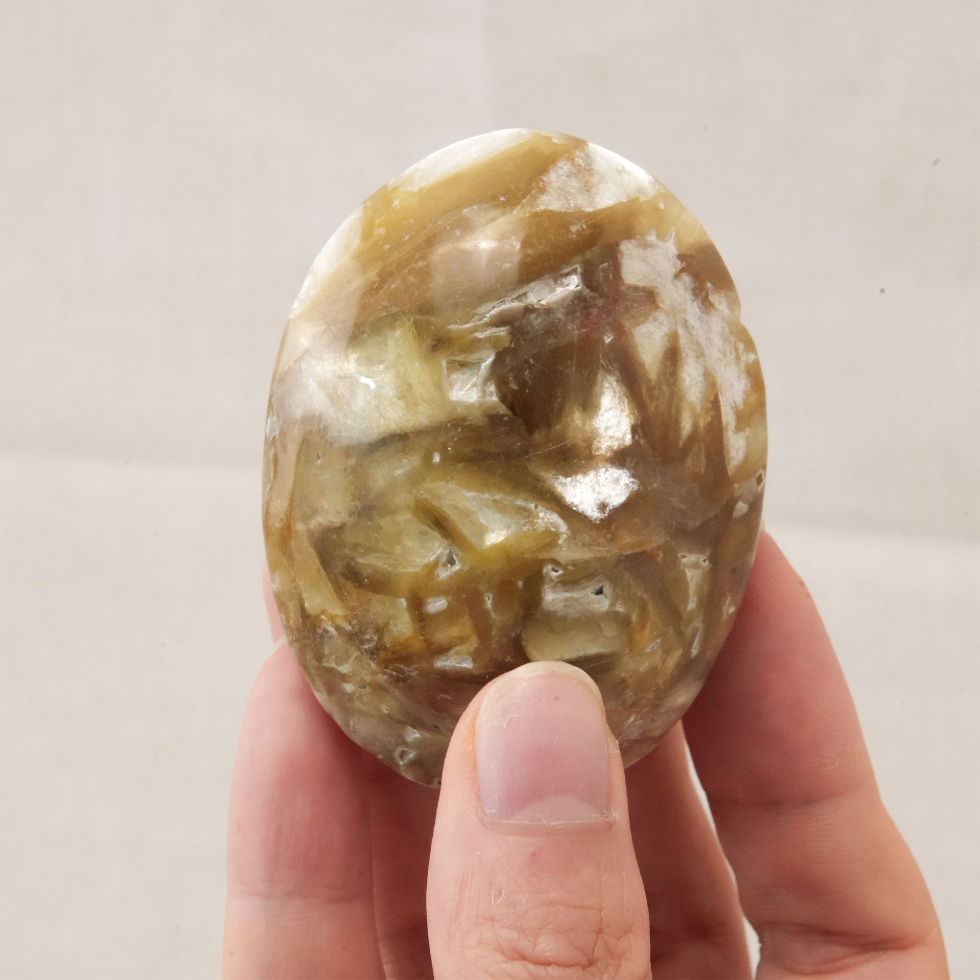 The Golden Lepidolite Palm Stone is a valuable tool for energy cleansing and emotional healing