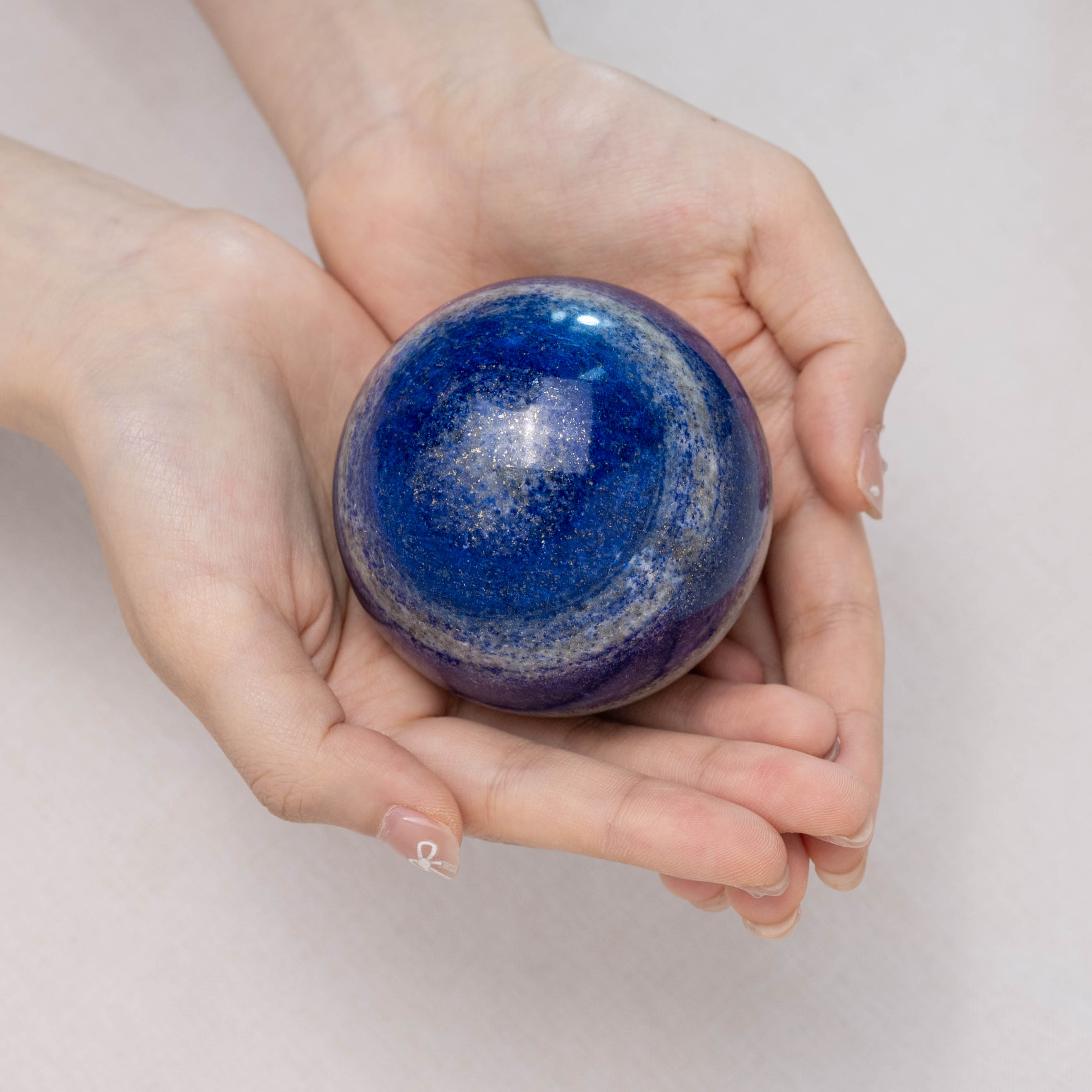 Natural lapis lazuli crystal ball, known for its spiritual benefits and intellectual stimulation.