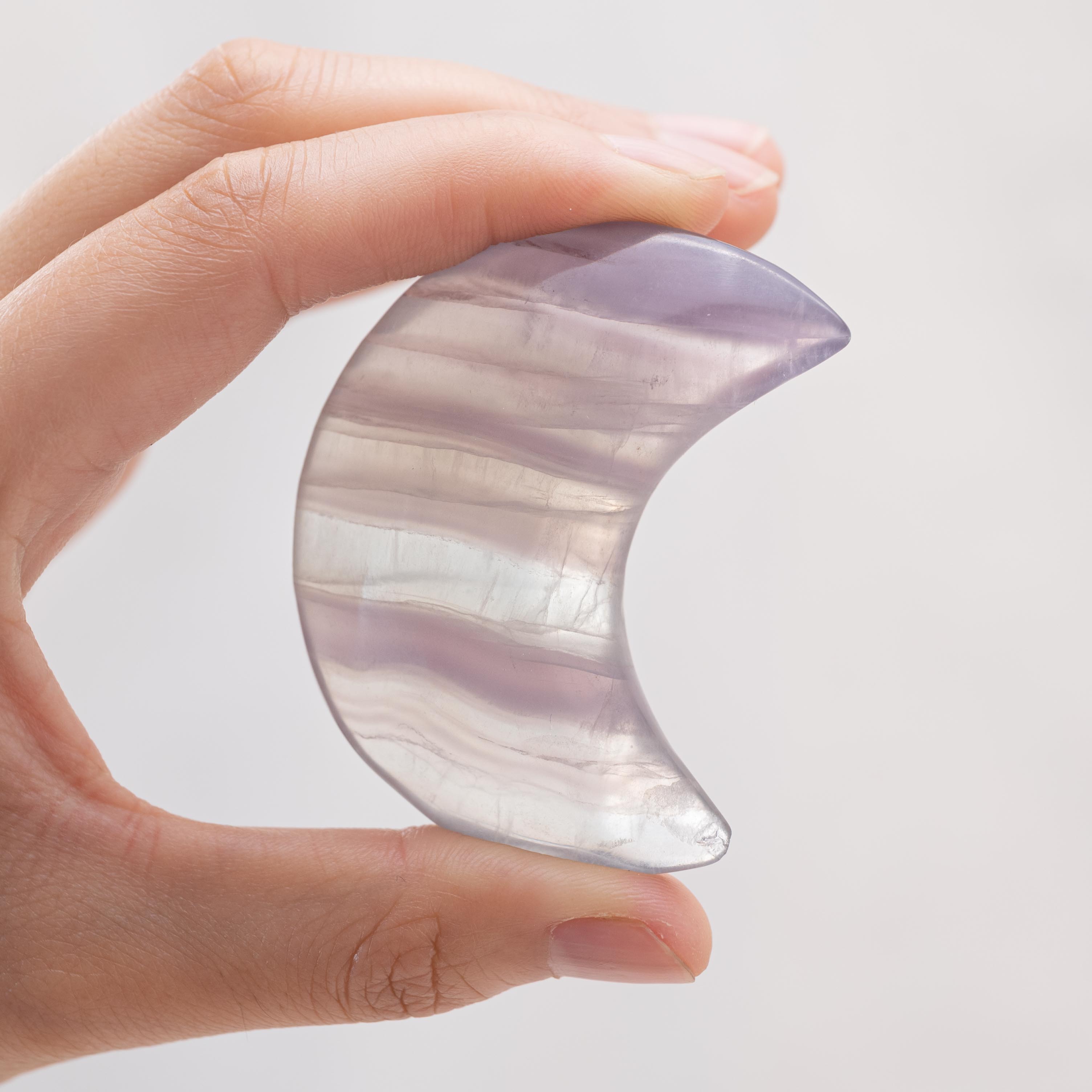 Display of Light Purple Fluorite Star/Moon Palm Stone