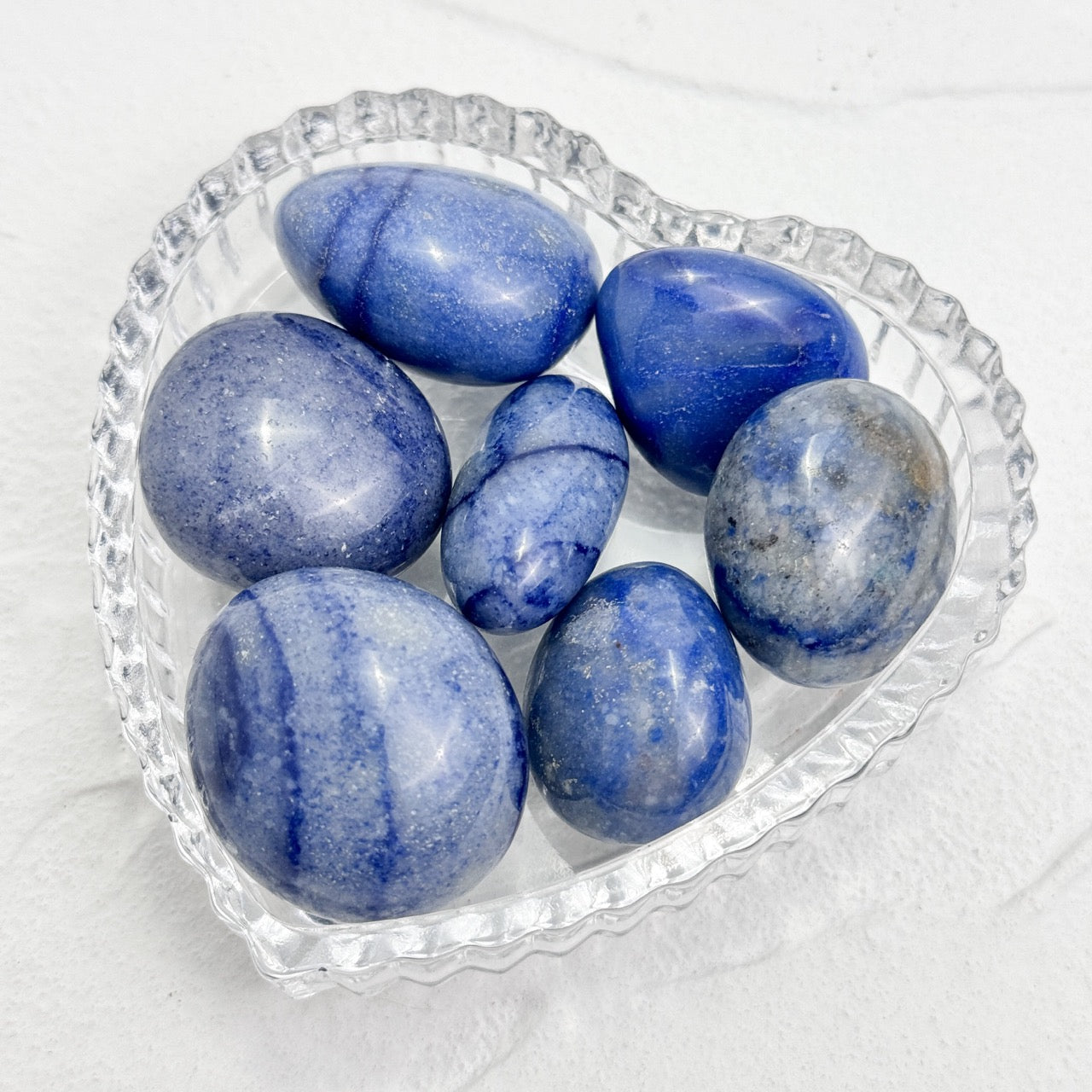 Hand-held blue aventurine stone displaying smooth texture and rich color