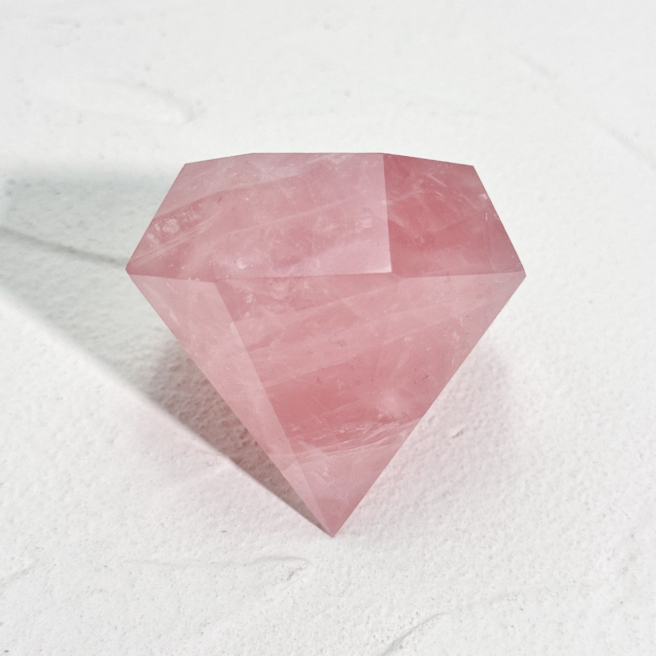 Elegant rose quartz diamond point on white background