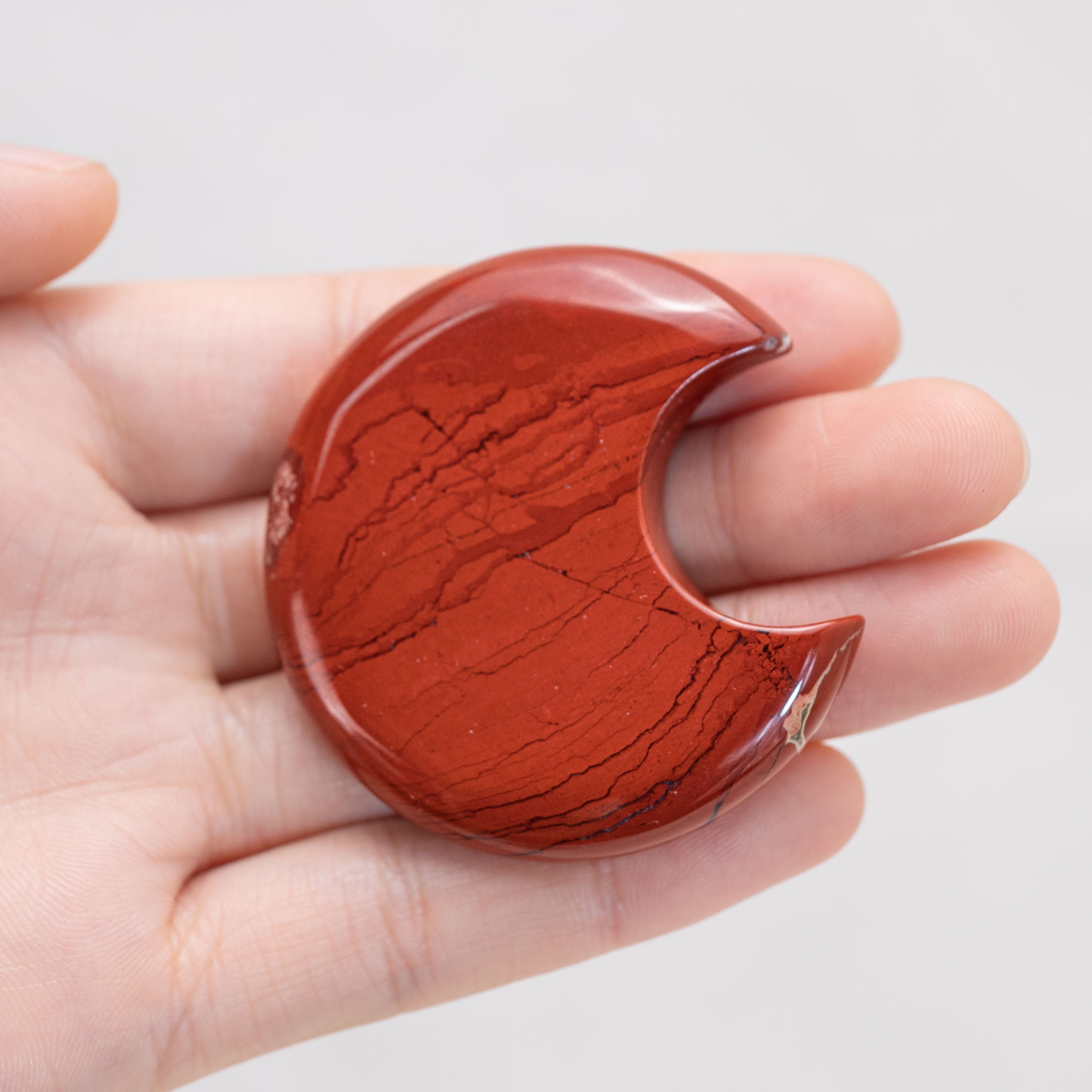 Hand holding Red Jasper Star/Moon Palm Stone
