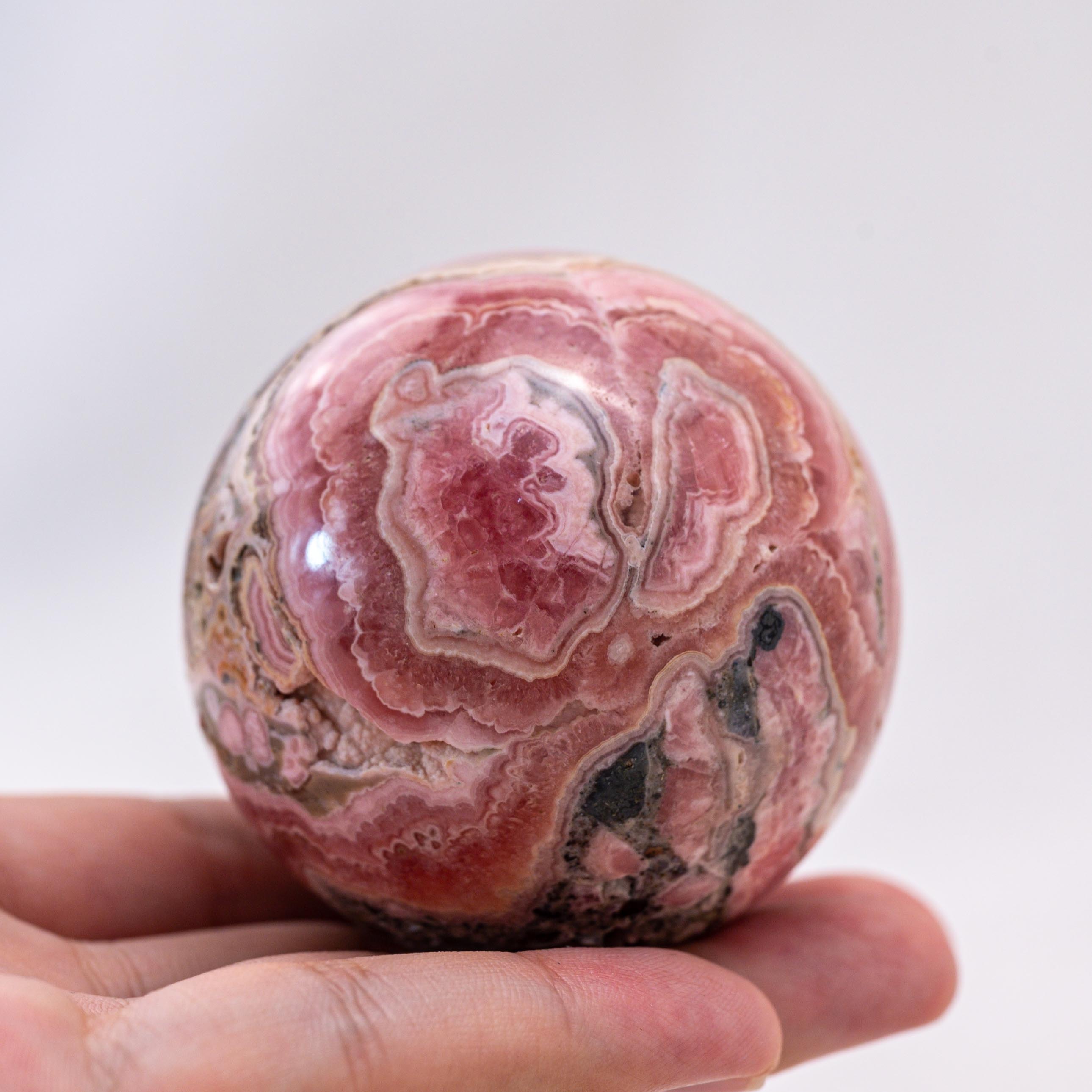 Unpolished rhodochrosite spheres promote emotional healing.