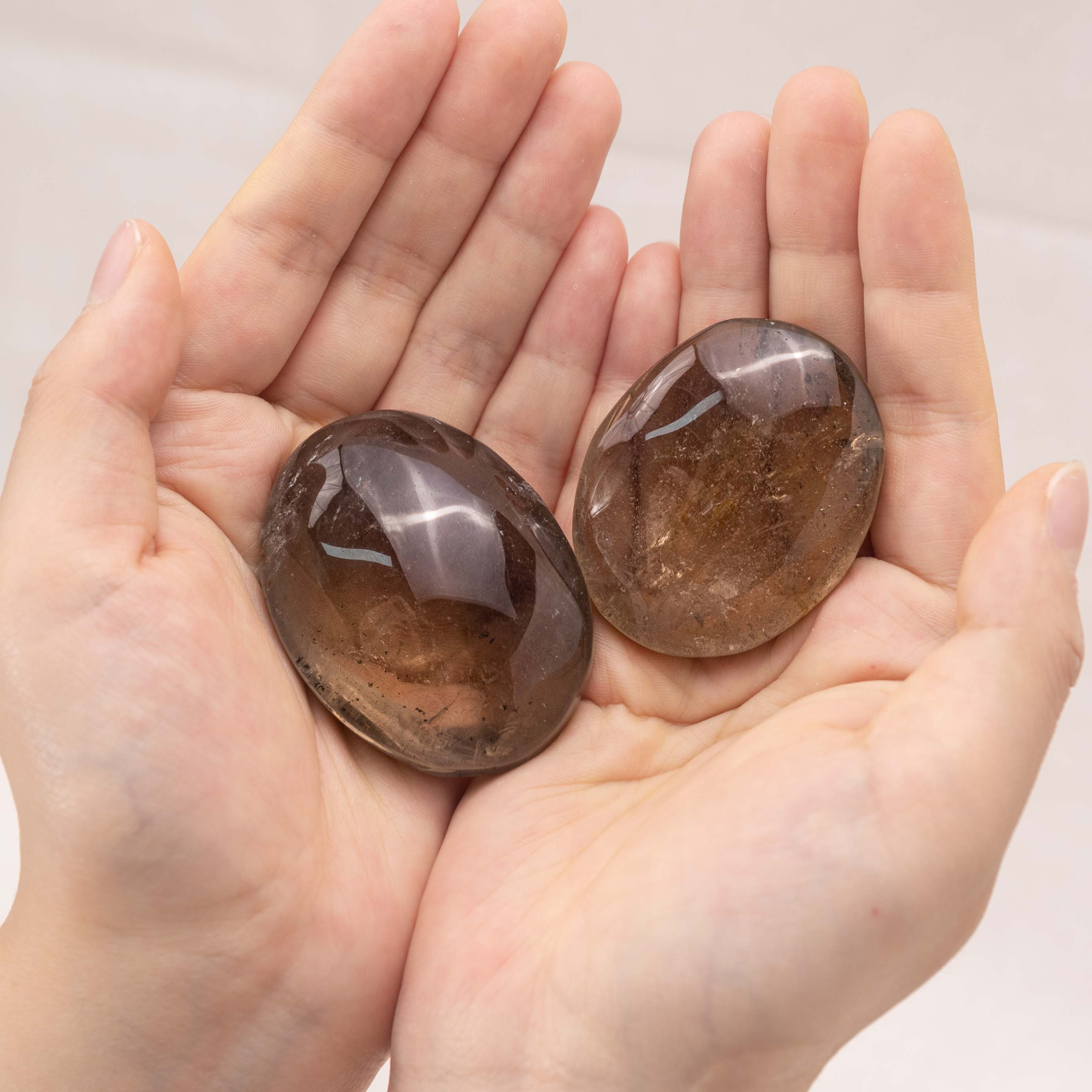 Detailed view of a smoky quartz palm stone’s rich, earthy hues, suitable for spiritual grounding.