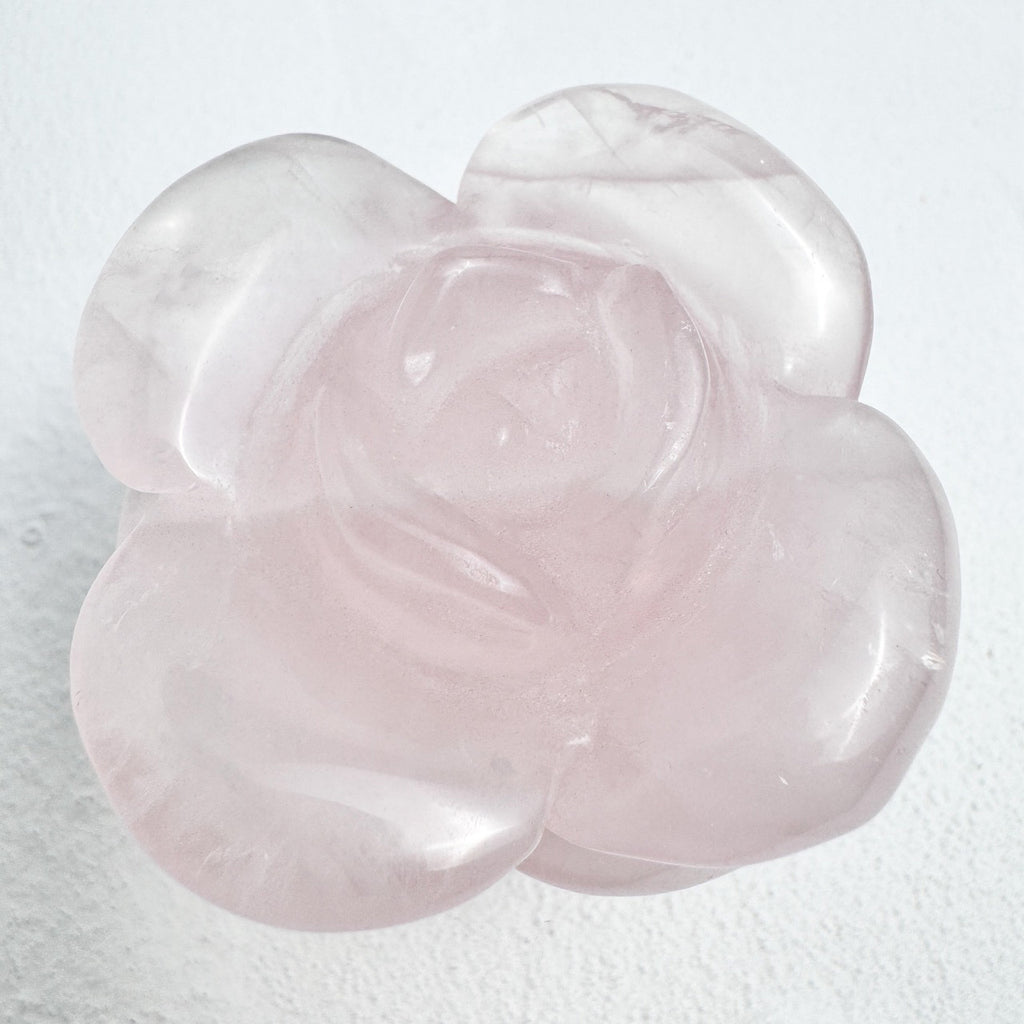 Natural rose quartz carved into a beautiful rose, showcasing craftsmanship