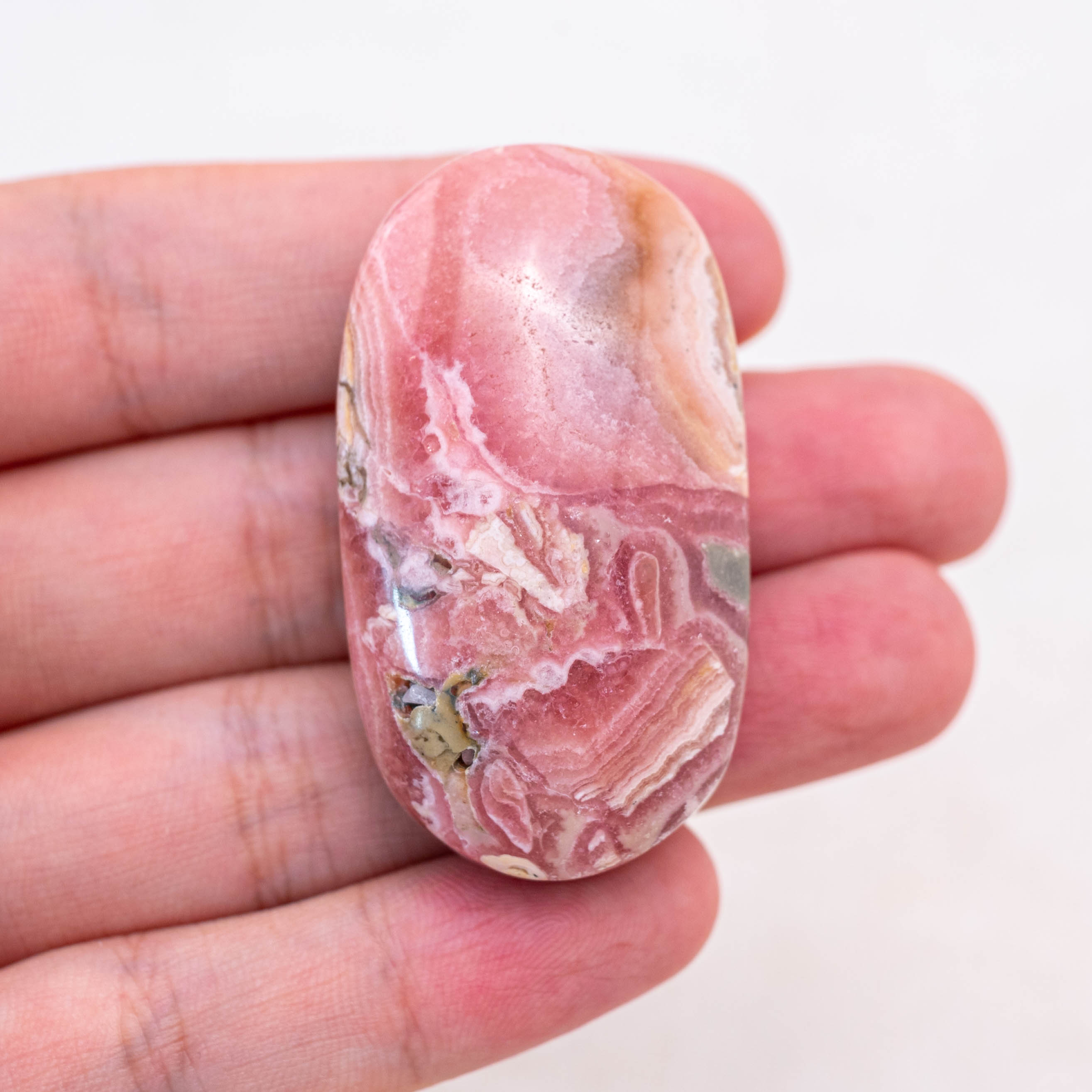 Unpolished rhodochrosite palm stones promote love and compassion.