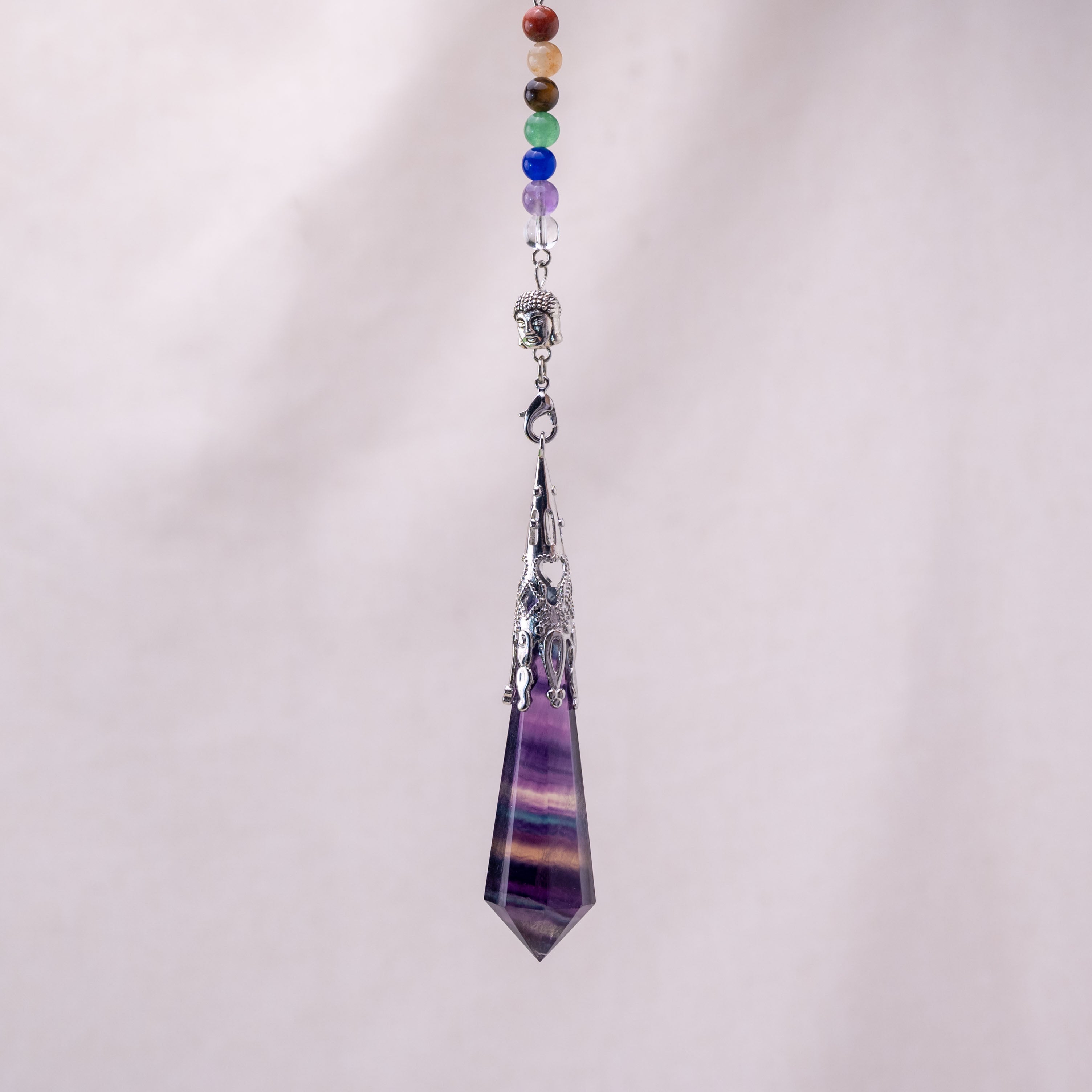 Crafted from high-quality fluorite, each pendulum features vibrant colors representing the seven chakras.